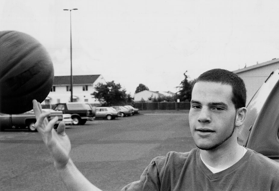 Garrett spinning a basketball in a parking lot